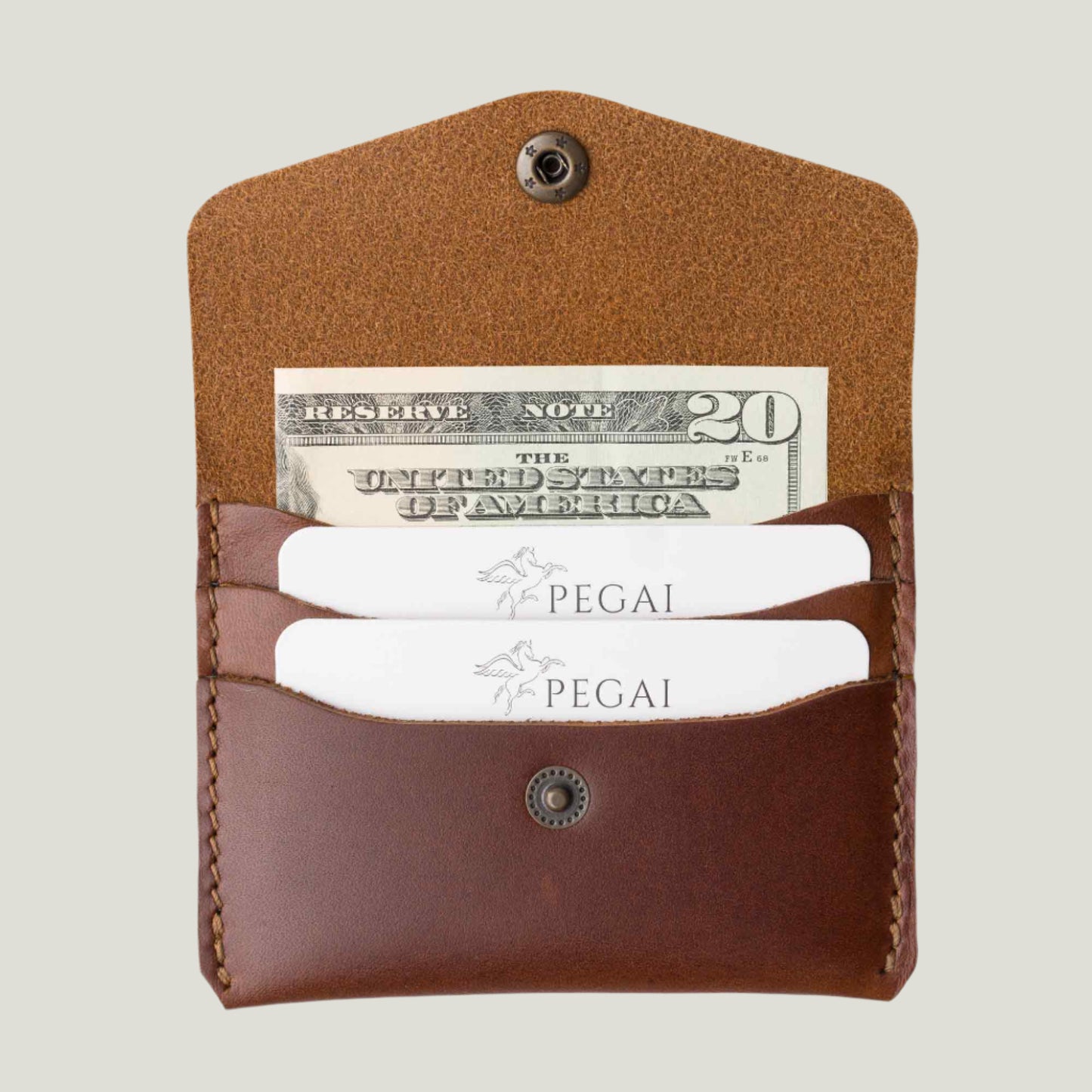 Handcrafted rum brown leather card holder with a slim design, holding up to 6 cards and 2 folded bills. Features fire-branded personalization for a unique touch.