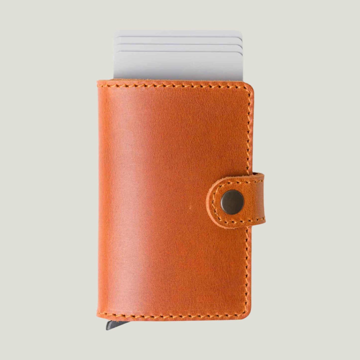 A handcrafted Agustine Leather Wallet in rich Whiskey brown, featuring quick card access with a sleek one-click trigger. Compact yet spacious, it holds up to five cards and folded bills. Designed by Atelier PEGAI, it blends timeless elegance with premium craftsmanship for everyday carry.
