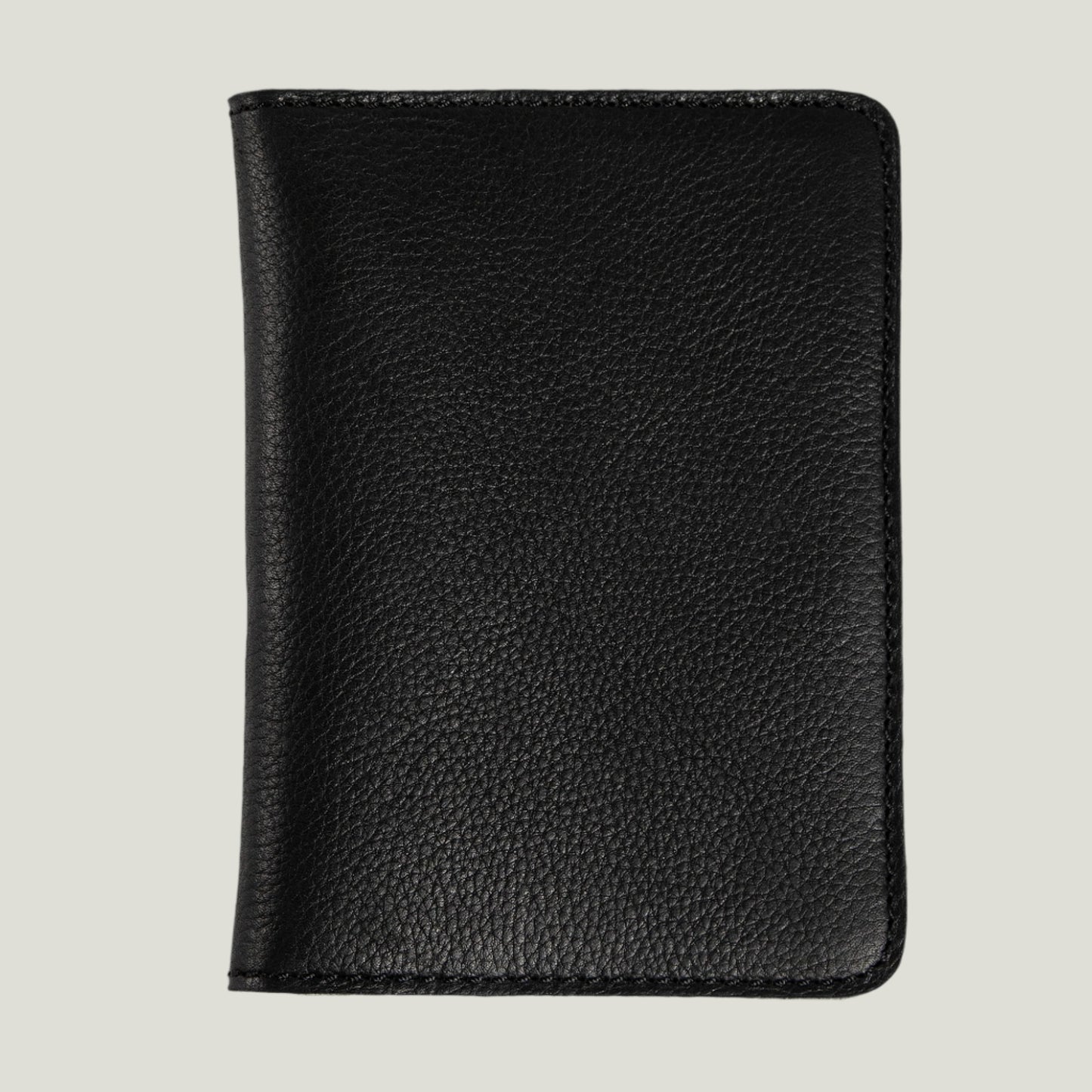 Close-up of the Pike Leather Passport Wallet in Dymnos Black, showcasing its sleek design, card slots, and fire-branded initials for a personalized touch.