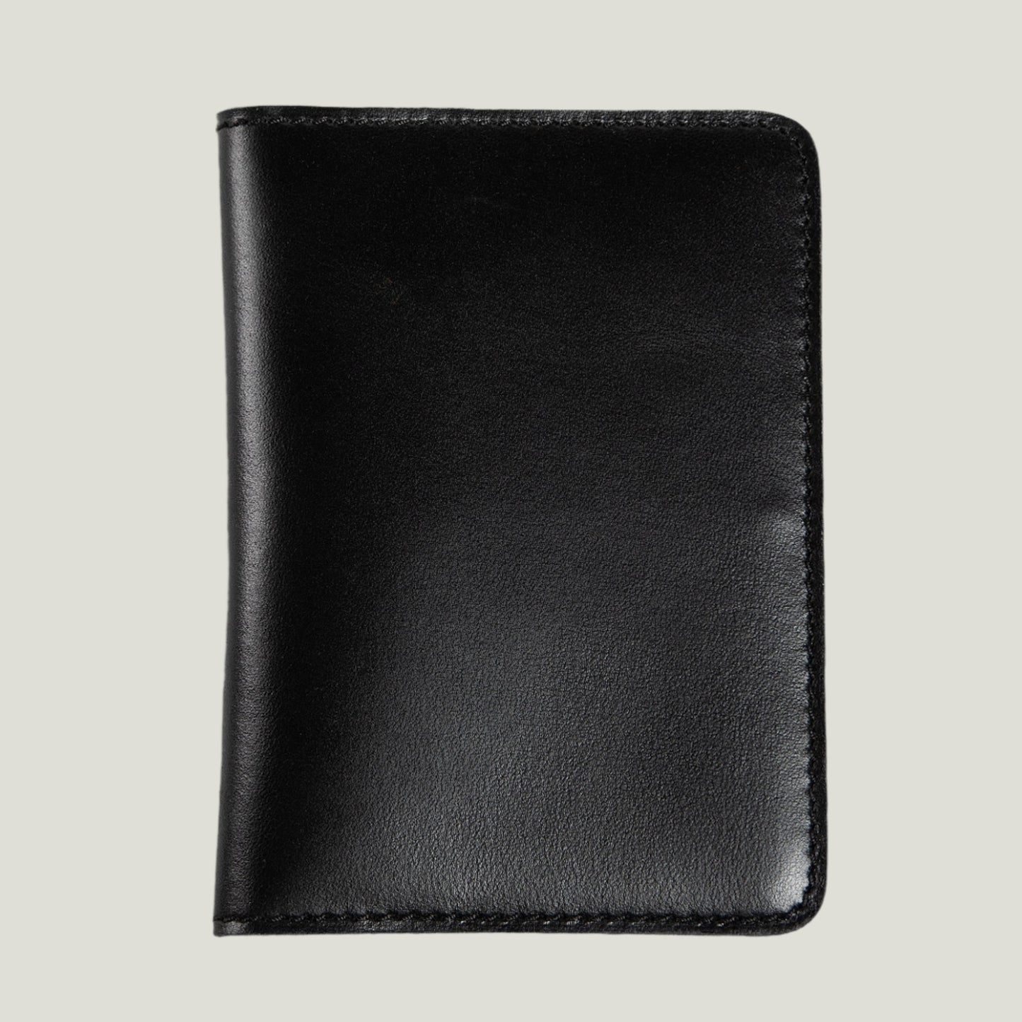 Close-up of the Pike Leather Passport Wallet in Dexios Black, handcrafted by Atelier PEGAI, featuring premium top-grain leather and fire-branded initials.