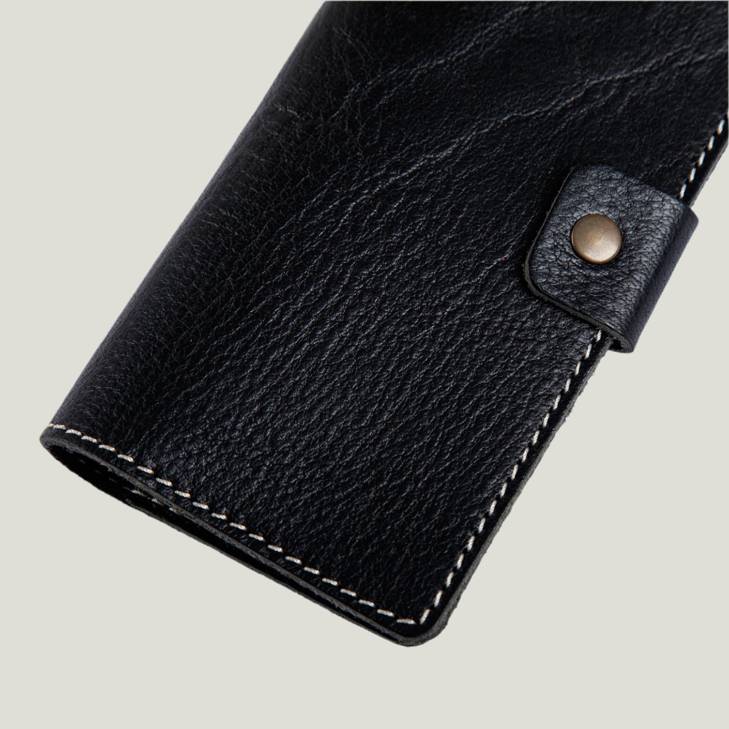 Phokion Black Clark Leather Checkbook Cover with antique brass snap, extra pocket, and personalized fire-branded initials, handcrafted in Ubrique by Tanner Leatherstein.