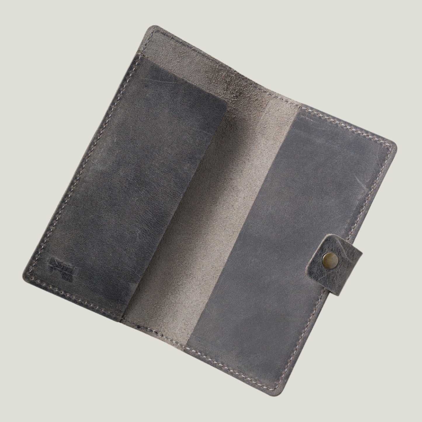 Close-up of the Clark Leather Checkbook Cover in Rock—top-grain leather with an antique brass snap closure, crafted for durability and personalization.