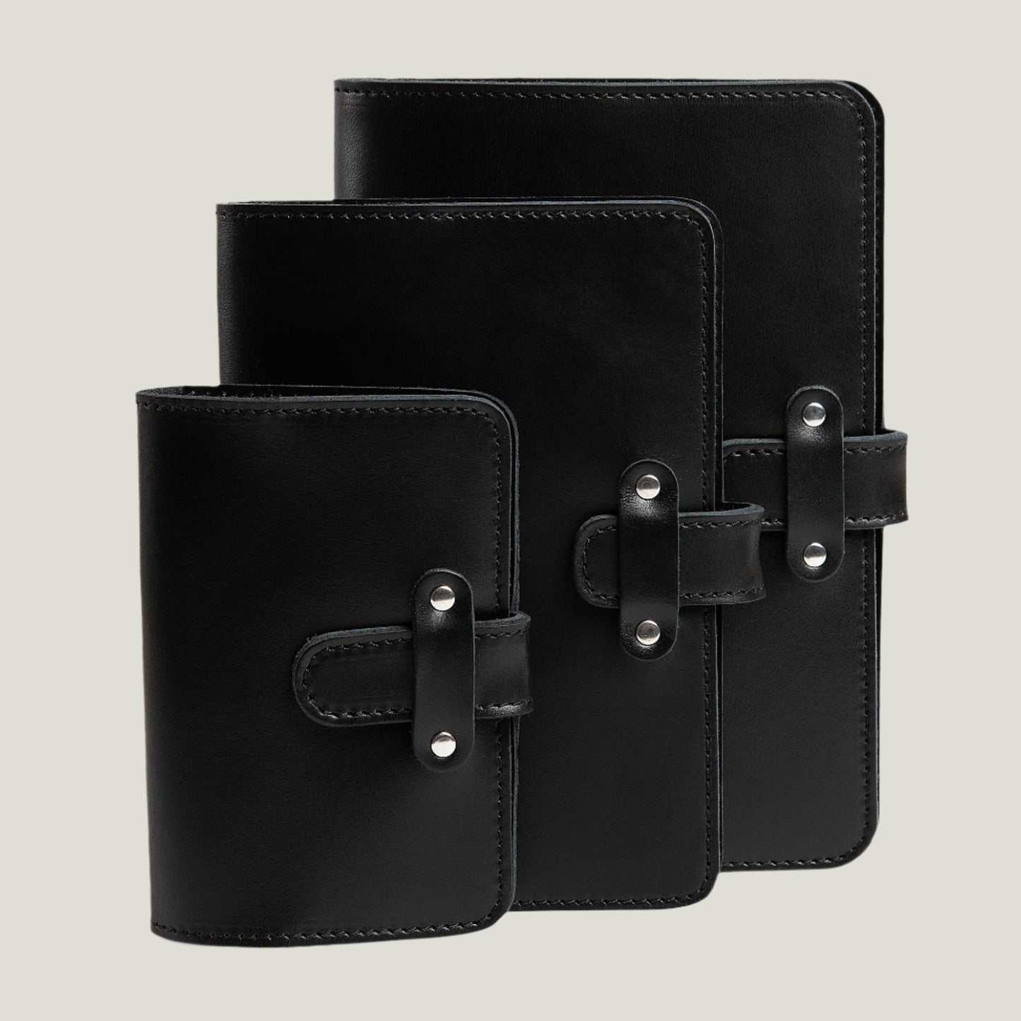 Handcrafted black leather journal with antique brass hardware, refillable pages, and a pen loop. Personalizable with fire-branded initials for a timeless touch.