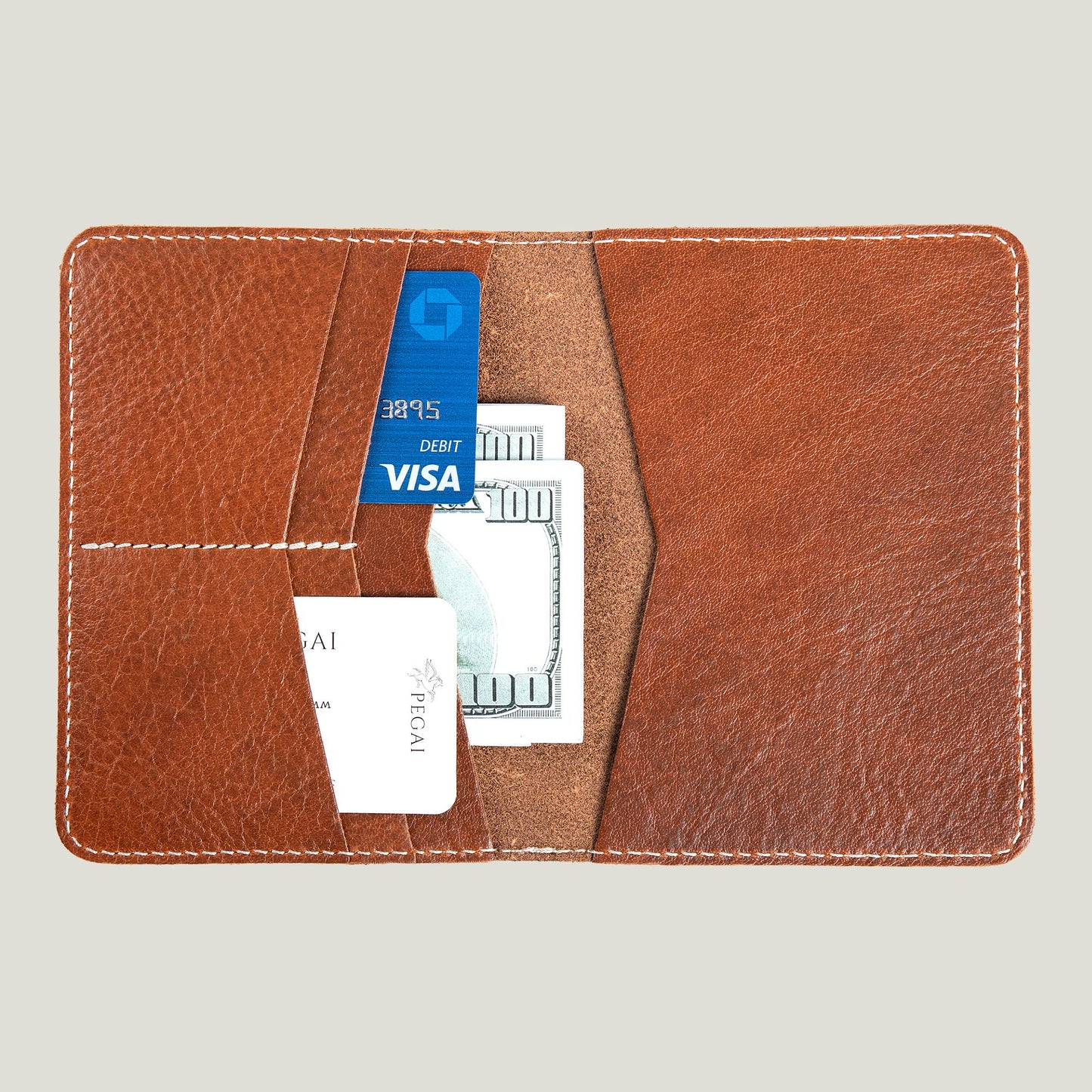 Close-up of the Pike Leather Passport Wallet in Phokion Brown, crafted from full-grain leather, featuring card slots and fire-branded personalized initials.