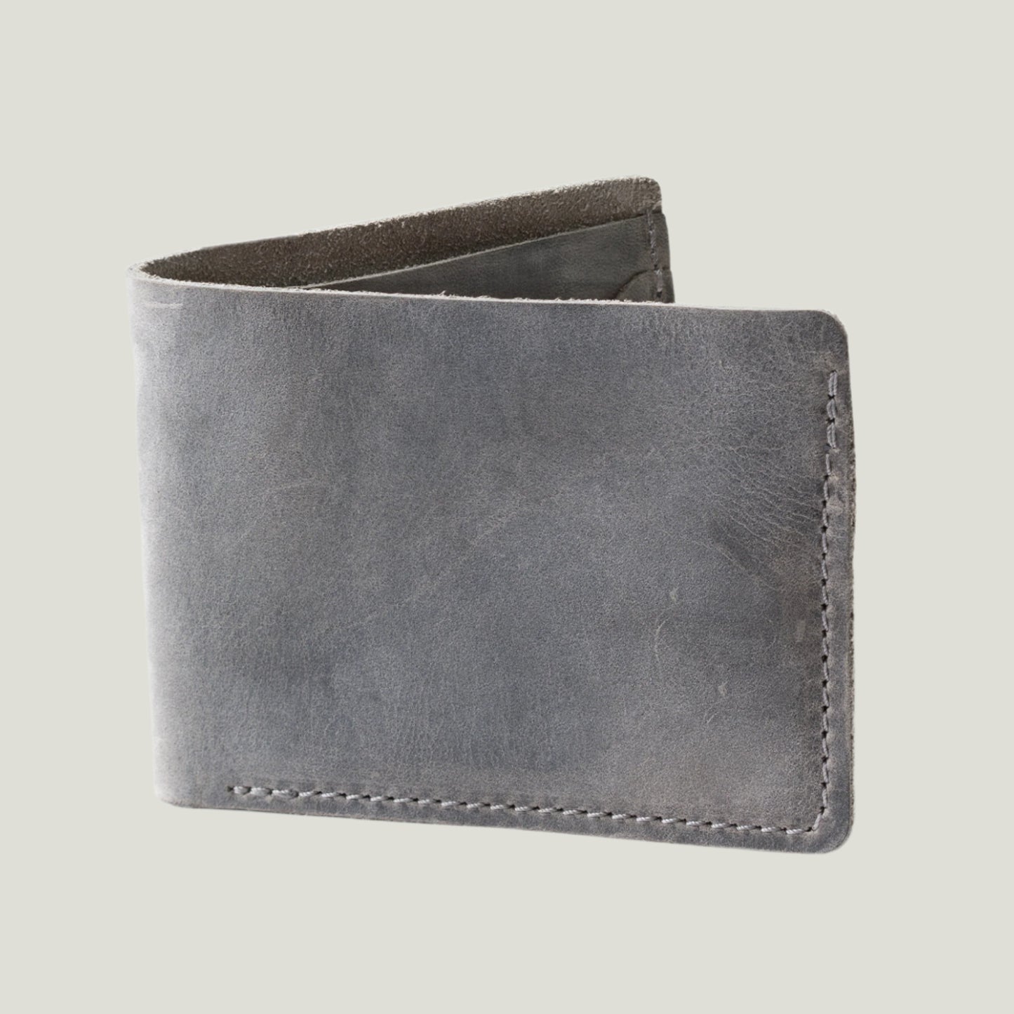 Close-up of the Bureau Leather Bifold Wallet in Rock, handcrafted from top-grain leather with a timeless design. Features fire-branded initials for personalization.