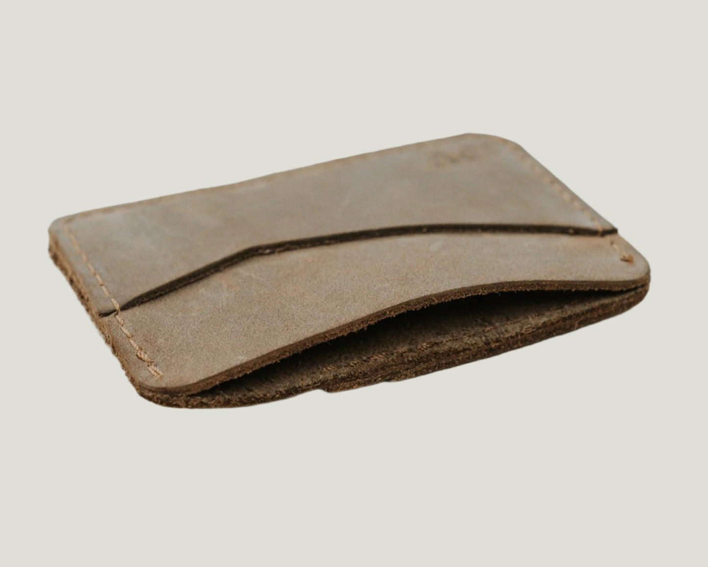 Slim leather cardholder in sand color, crafted from top-grain distressed leather. Holds up to 6 cards with a hidden cash pocket. Personalizable with initials.