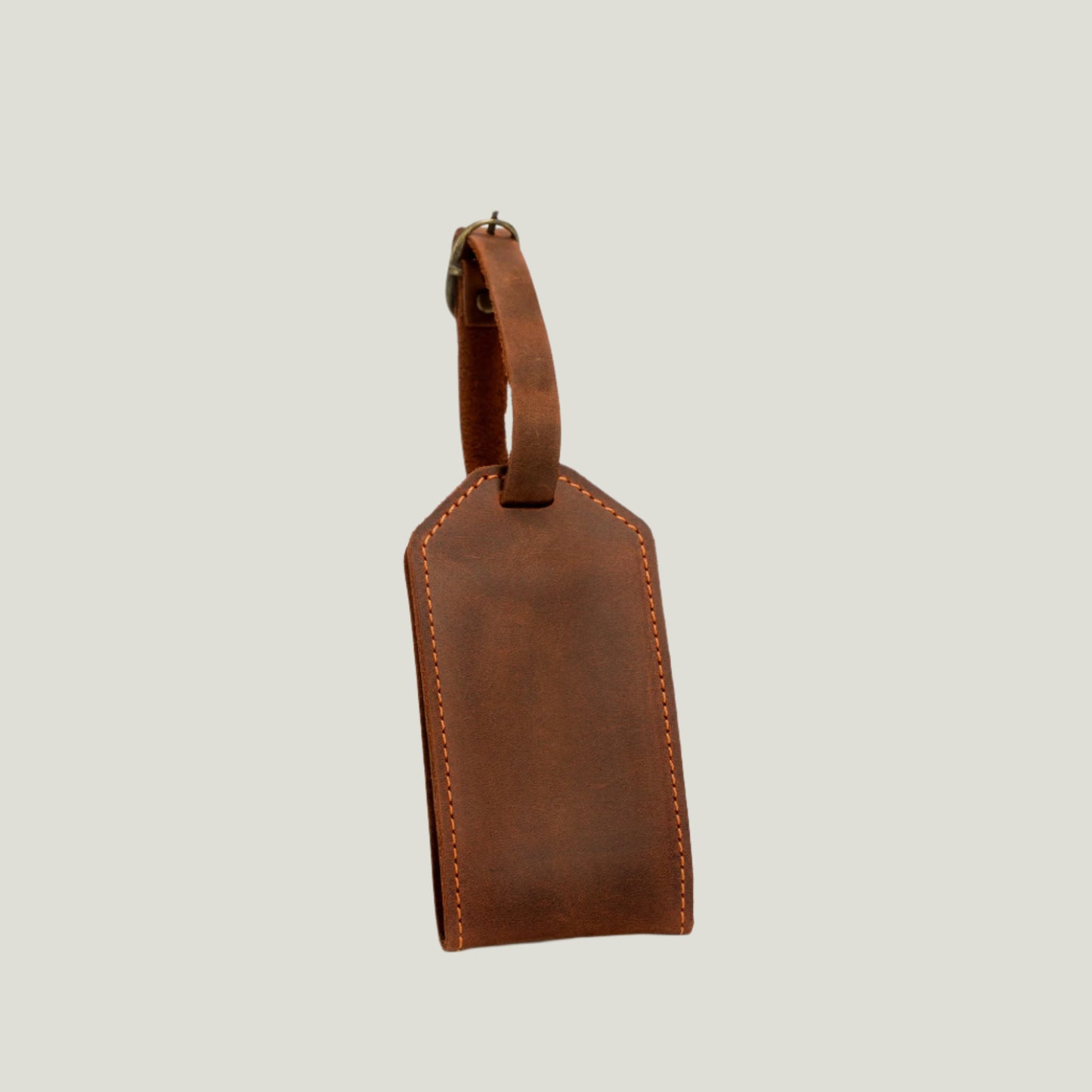 Mahogany Bond Leather Luggage Tag with antique brass hardware, suede interior, and adjustable strap. Personalizable with fire-branded initials for a unique touch.