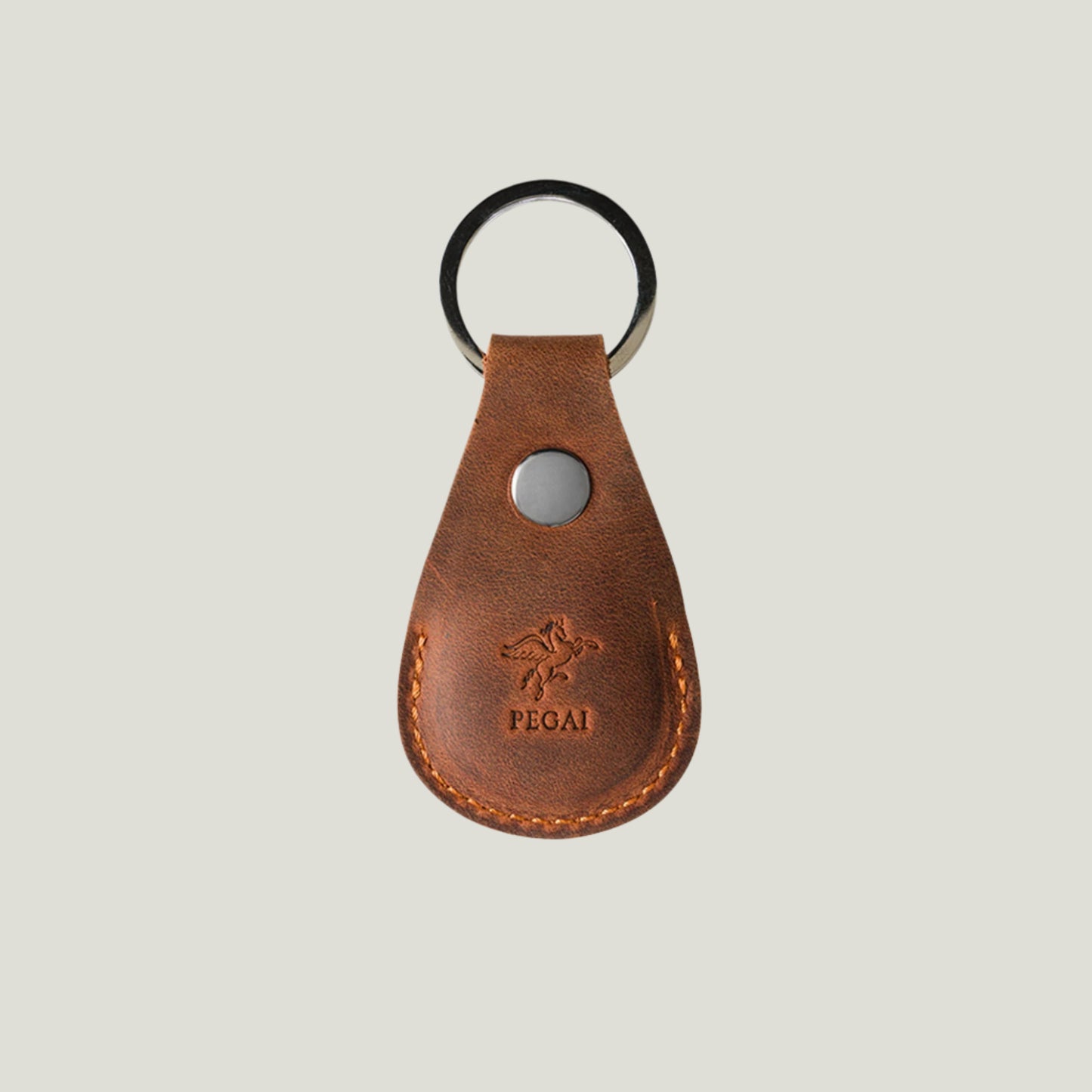 Mahogany Pear Leather AirTag Holder by Atelier PEGAI, designed by Tanner Leatherstein. Elegant, handcrafted leather accessory for securing keys, bags, and more.