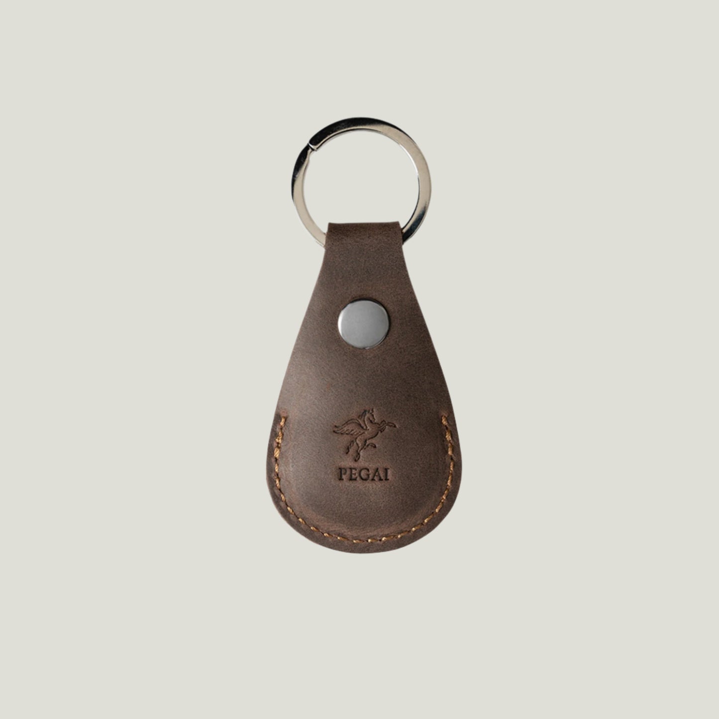 Chestnut Pear Leather AirTag Holder by Atelier PEGAI, crafted in Spain with premium leather, snap closure, and nickel hardware—designed for Apple AirTag.