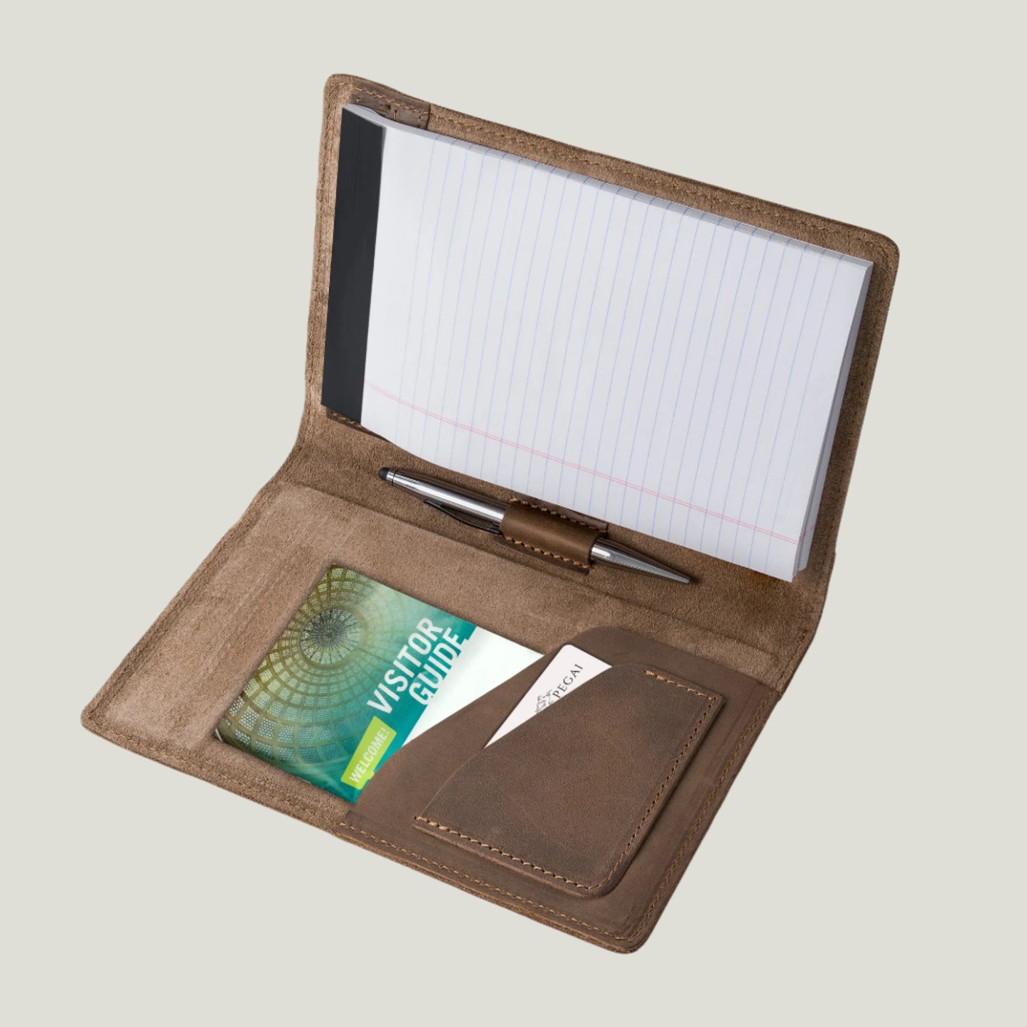 Elegant sand-colored leather padfolio with a pen holder, business card slot, and inside pocket, crafted by Atelier PEGAI. Designed for 8” x 5” legal pads, this handcrafted piece blends rustic charm with personalization, featuring fire-branded initials for a timeless, bespoke touch.