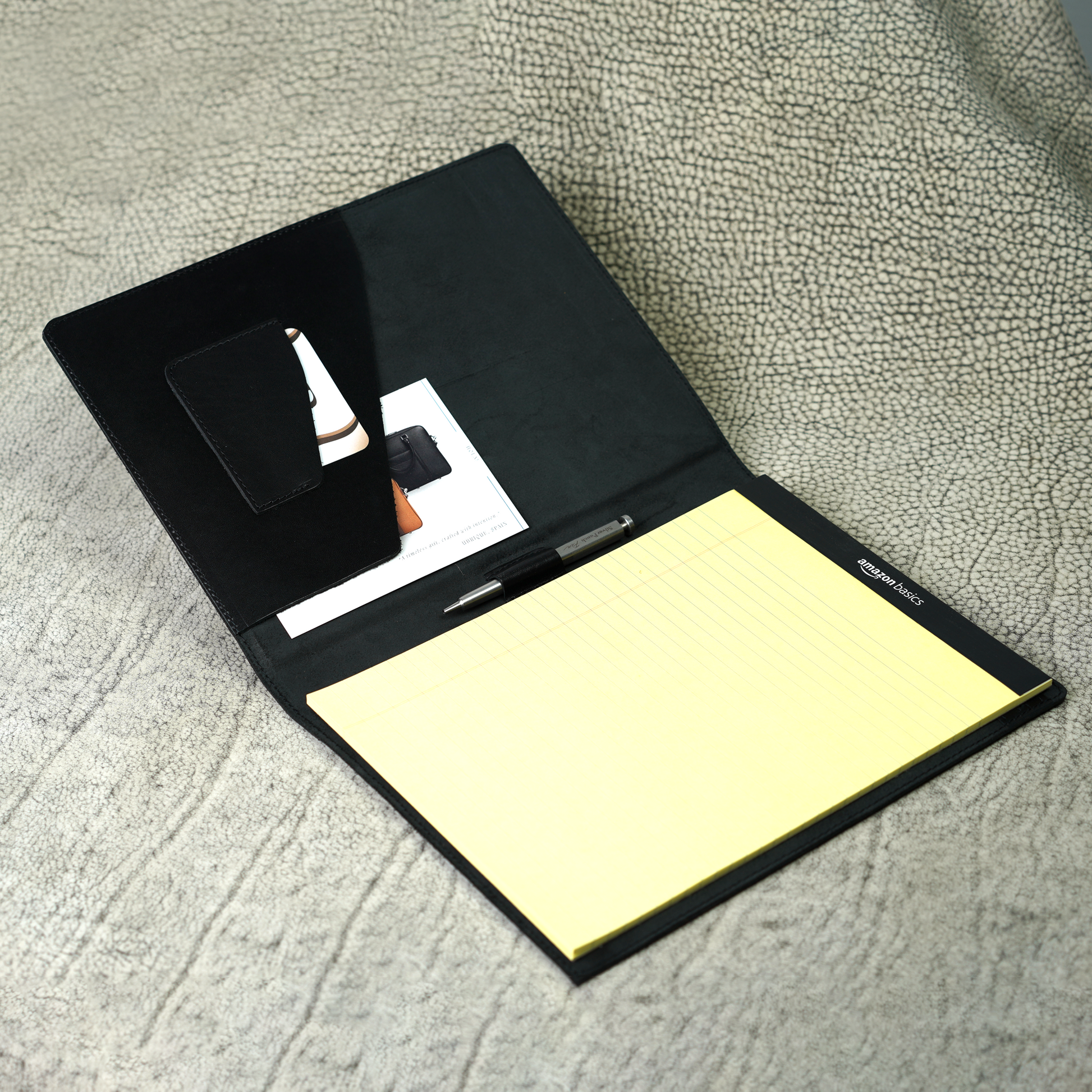 Marshall Leather Legal Padfolio open to reveal pen holder, card slot, and A4 document pocket with a yellow legal pad. Crafted from full-grain leather in Djor Black, this minimalist organizer blends classic style with purposeful design.