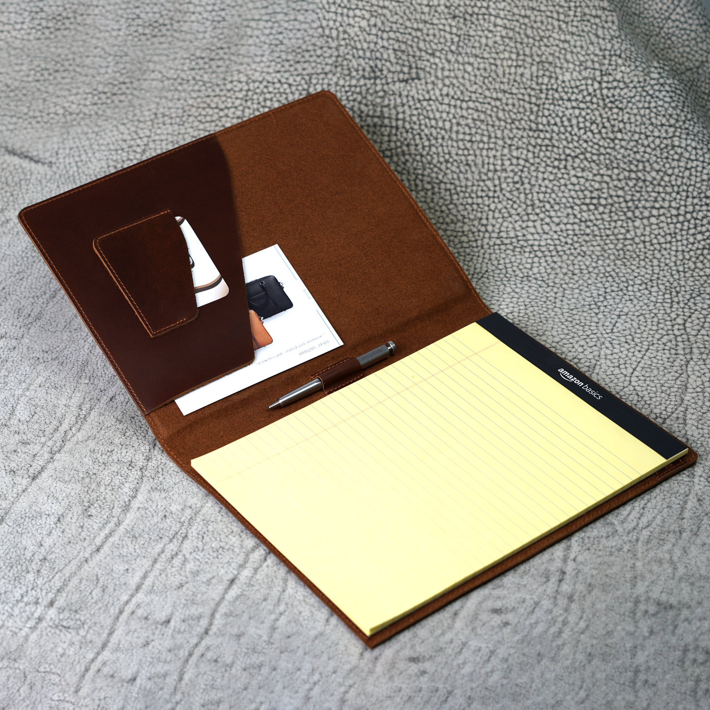 Marshall Leather Legal Padfolio in Djor Brown, opened to reveal pen loop, angled card slot, and A4 folder pocket with a standard yellow legal pad inside. Handcrafted from rugged full-grain leather, this padfolio blends timeless style with practical organization—built for professionals who lead with quiet confidence.