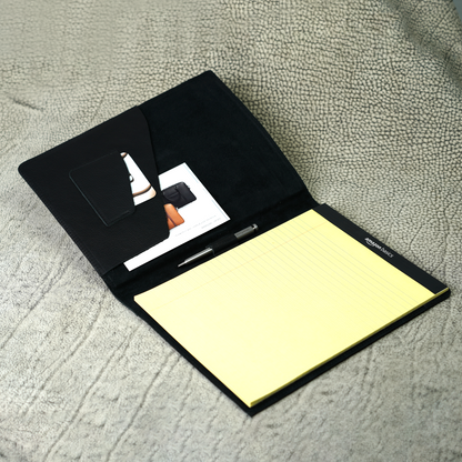 Marshall Leather Legal Padfolio in Dymnos Black, open to reveal a pen holder, angled card pocket, and document sleeve with a yellow legal pad inserted. Designed for clarity and confidence, this handcrafted full-grain leather organizer is built for professionals who mean business—without saying a word.
