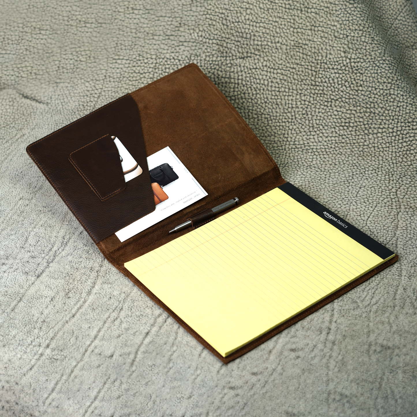 Marshall Leather Legal Padfolio in Dymnos Brown, open to reveal a pen holder, angled business card pocket, and spacious A4 document sleeve with a yellow legal pad. Made from full-grain leather and crafted with purpose—designed to keep essentials organized and your mindset sharp.