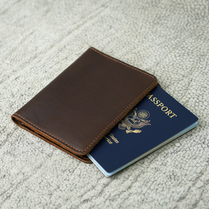 A handcrafted Pike Leather Passport Wallet in smooth Dymnos Brown leather, shown partially open with a U.S. passport inside. Rich brown tones, natural grain, and careful stitching reflect timeless quality and the spirit of meaningful travel.