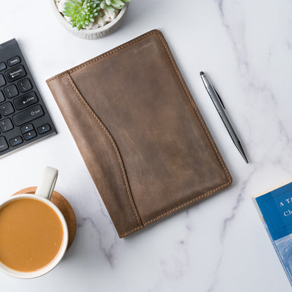 Elegant sand-colored leather padfolio with a pen holder, business card slot, and inside pocket, crafted by Atelier PEGAI. Designed for 8” x 5” legal pads, this handcrafted piece blends rustic charm with personalization, featuring fire-branded initials for a timeless, bespoke touch.
