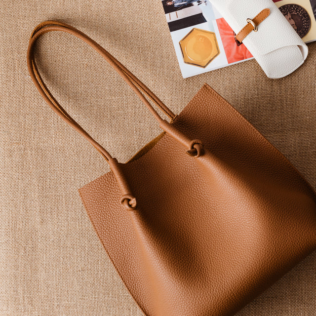 Flora Everyday Leather Tote in Togo Calf Taba with suede interior, rolled handles, and hand-finished edges—crafted for everyday function and rustic charm.