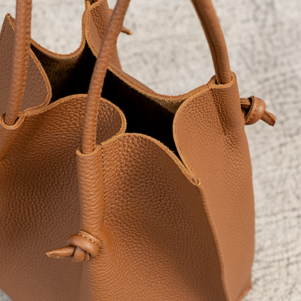 Flora Everyday Leather Tote in Togo Calf Taba with suede interior, rolled handles, and hand-finished edges—crafted for everyday function and rustic charm.