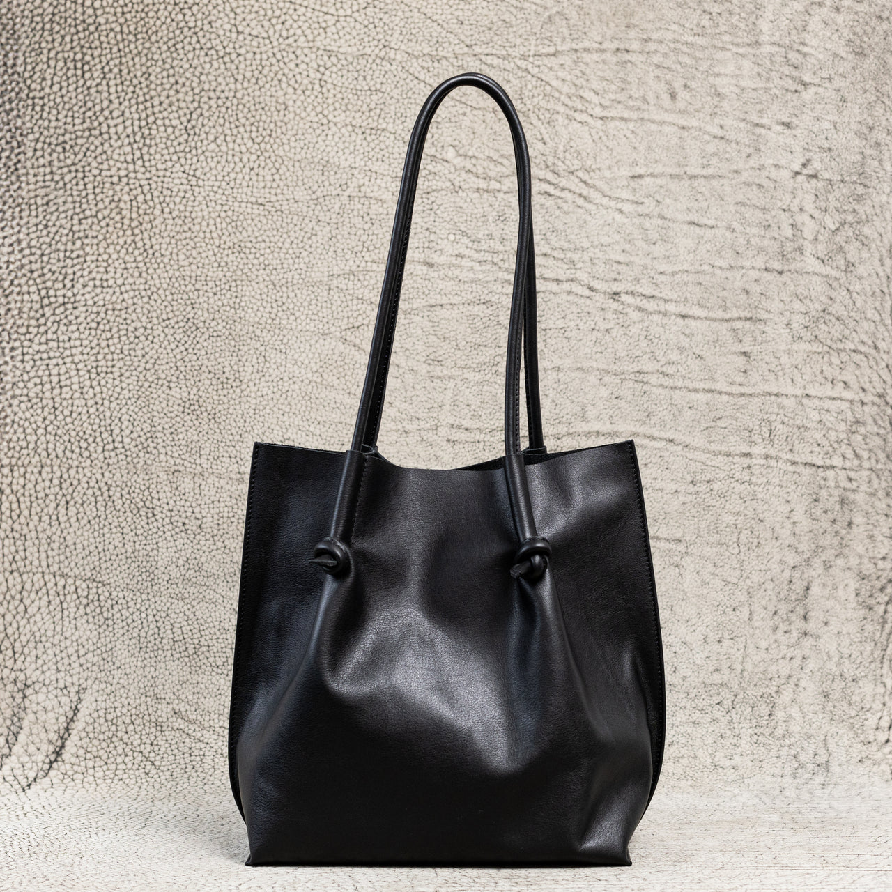 Flora Everyday Leather Tote in Smooth Calf Black with suede interior, rolled handles, and hand-finished edges—crafted for everyday elegance and ease.