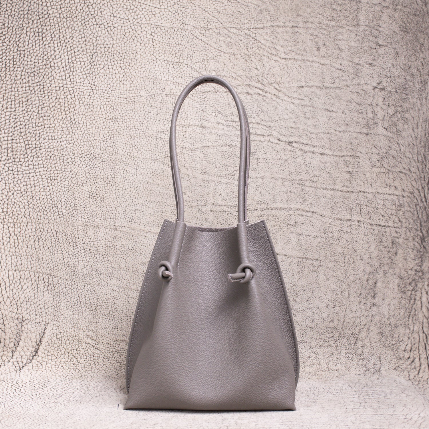 Front-facing view of the Flora Everyday Tote in Togo Gris, showing its softly structured form and knotted leather handles.