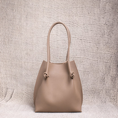 Front view of the Flora Tote in Togo Etoupe leather, displaying its structured silhouette and soft pebbled texture.