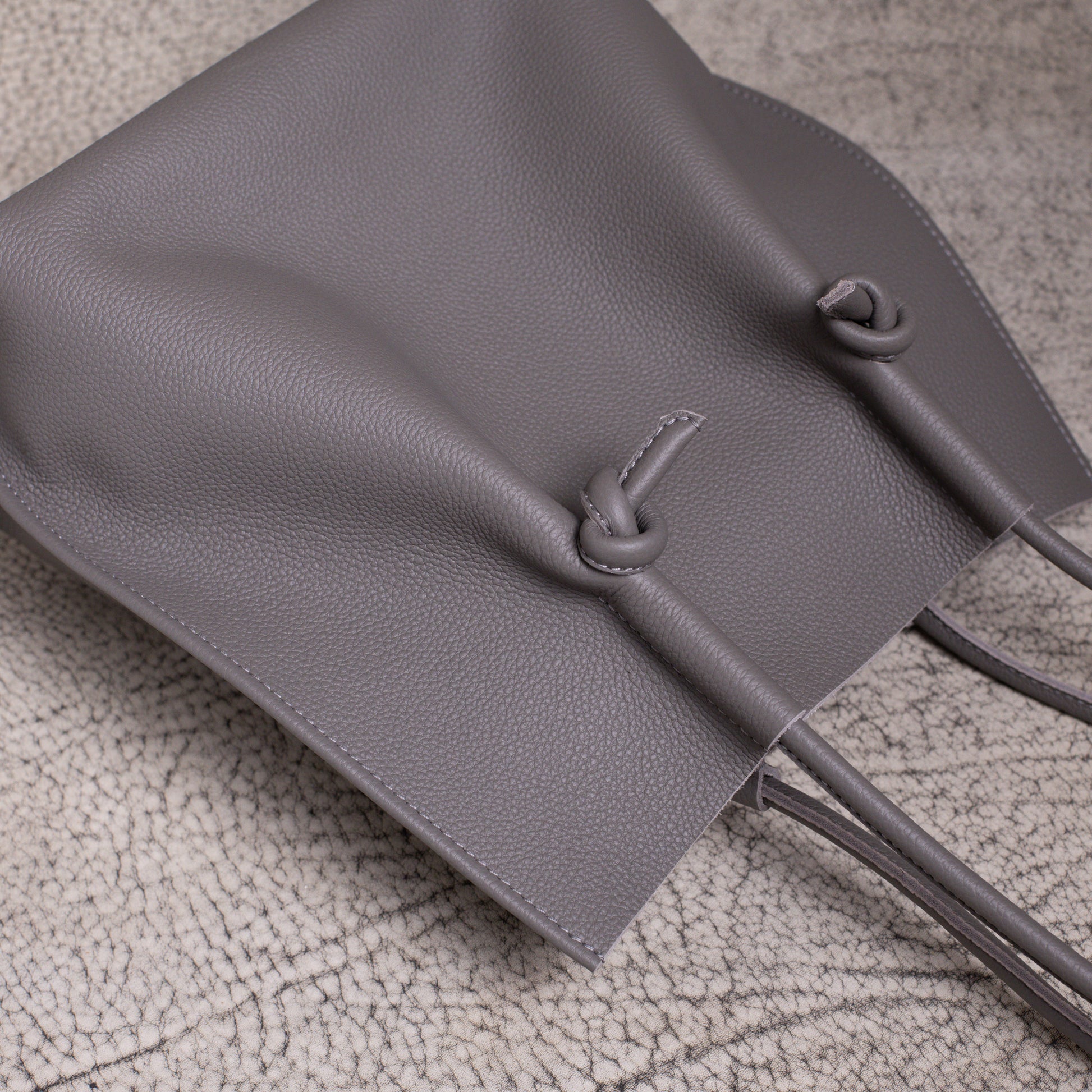 Flat lay from above showing the relaxed shape of the Flora tote, with the handles and knotted design resting naturally.
