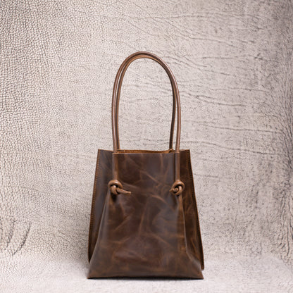 Front view of the Flora Everyday Leather Tote in dual-tone coffee, showcasing its knotted rolled handles and rich artisan leather finish.