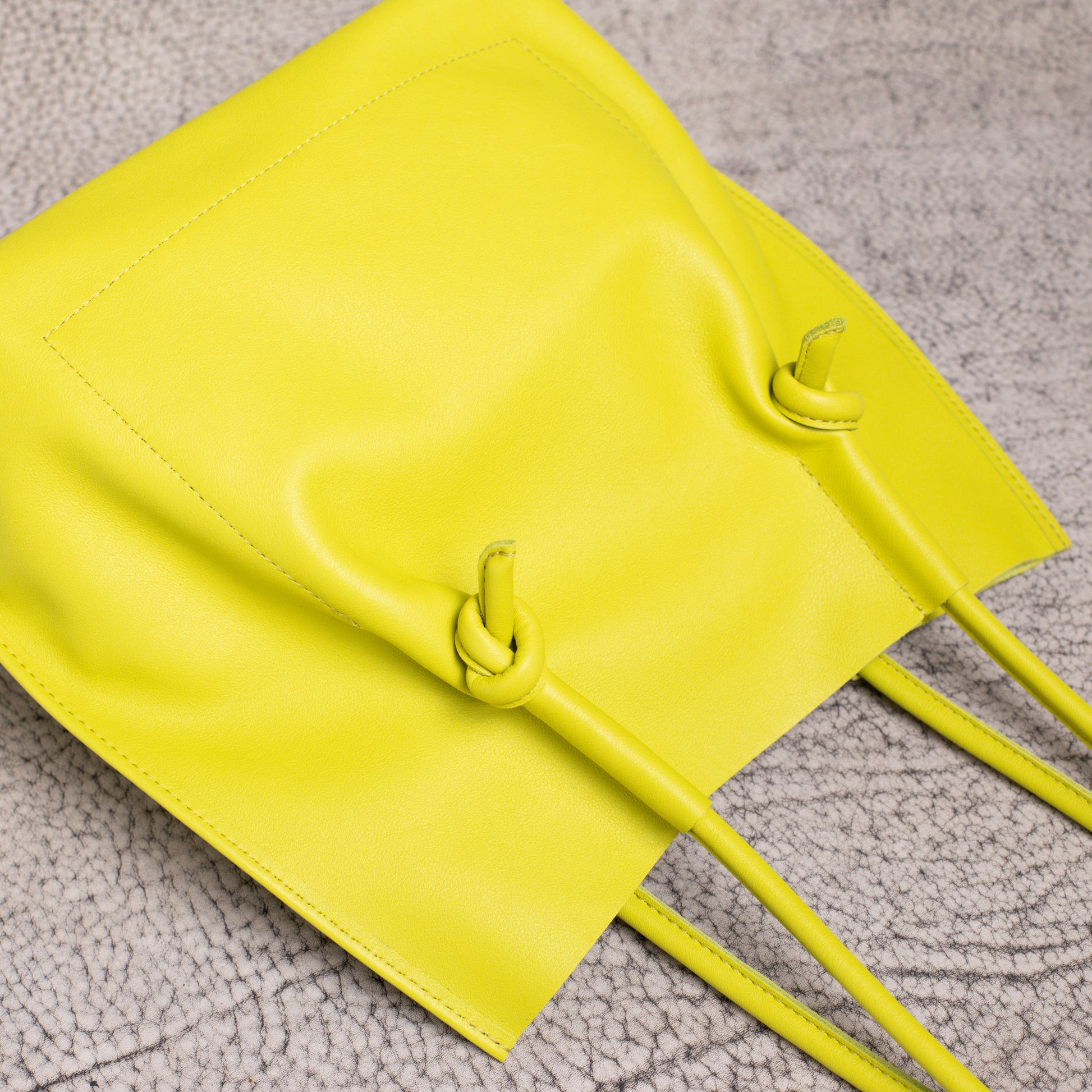 Close-up of the Flora Tote’s base and handle knots, showcasing precise stitching and folded-edge craftsmanship.