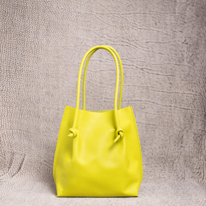 Front view of the Flora Everyday Leather Tote in Silky Calf Lime, showing its minimal design, knotted handles, and smooth leather finish.