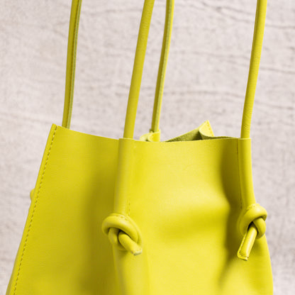 Detailed view of the dual-rolled leather handles and top edge of the Flora Tote, emphasizing the soft texture and construction quality.