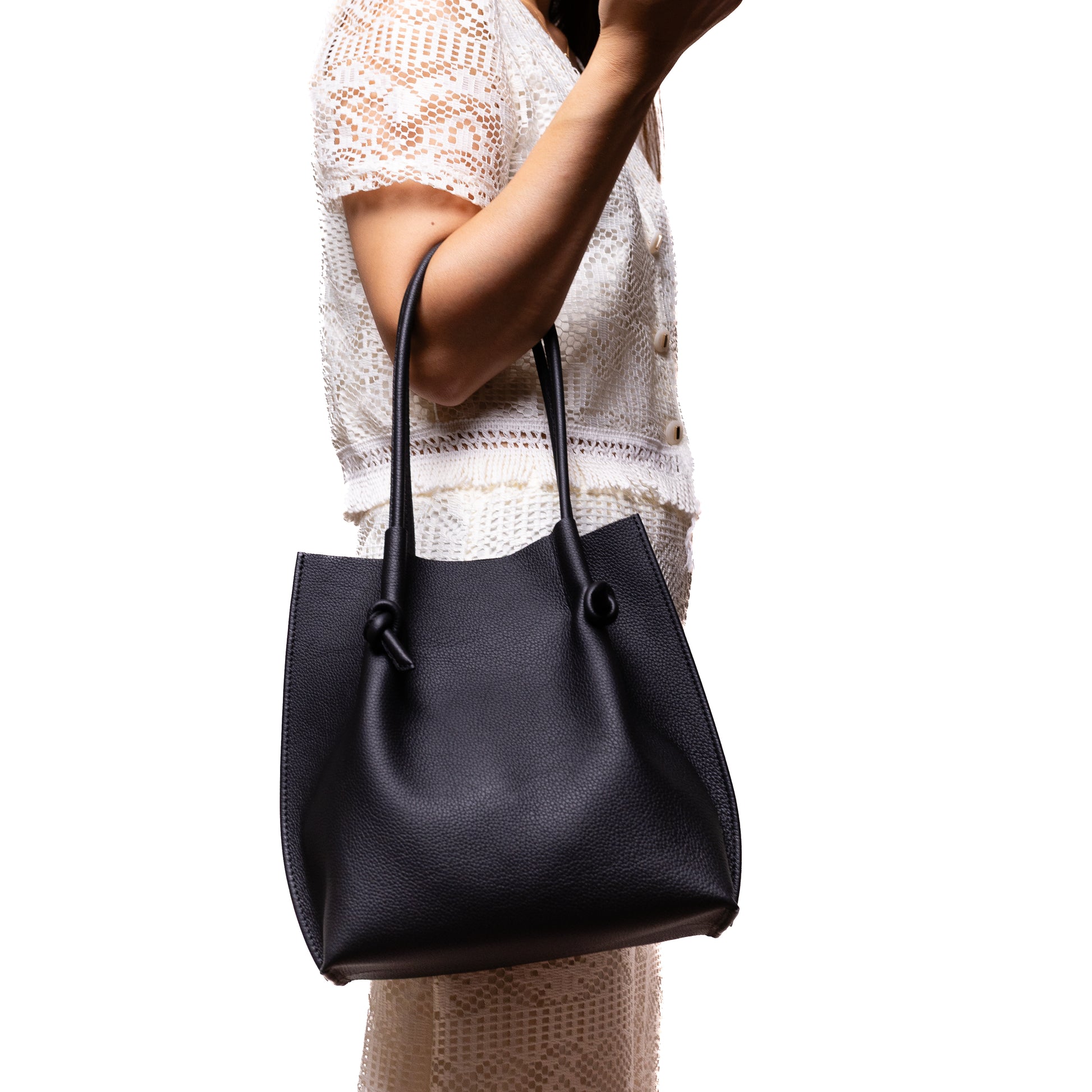 Model holding the Flora Everyday Tote over her arm, showing the bag’s real-life scale and versatile styling with a modern outfit.
