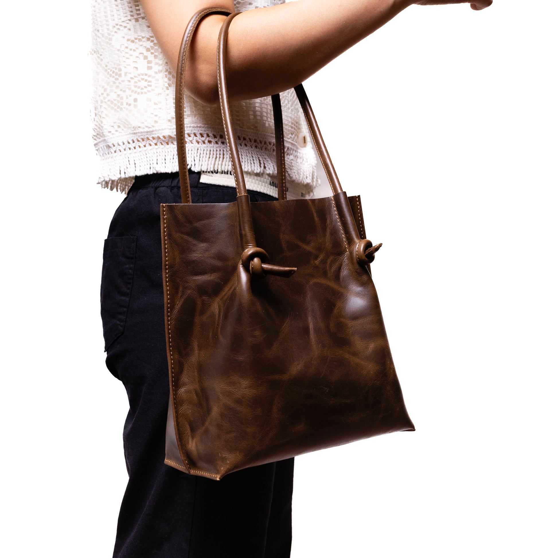 Model carrying the Flora Everyday Tote by the handles, demonstrating its comfortable drop length and polished silhouette in use.