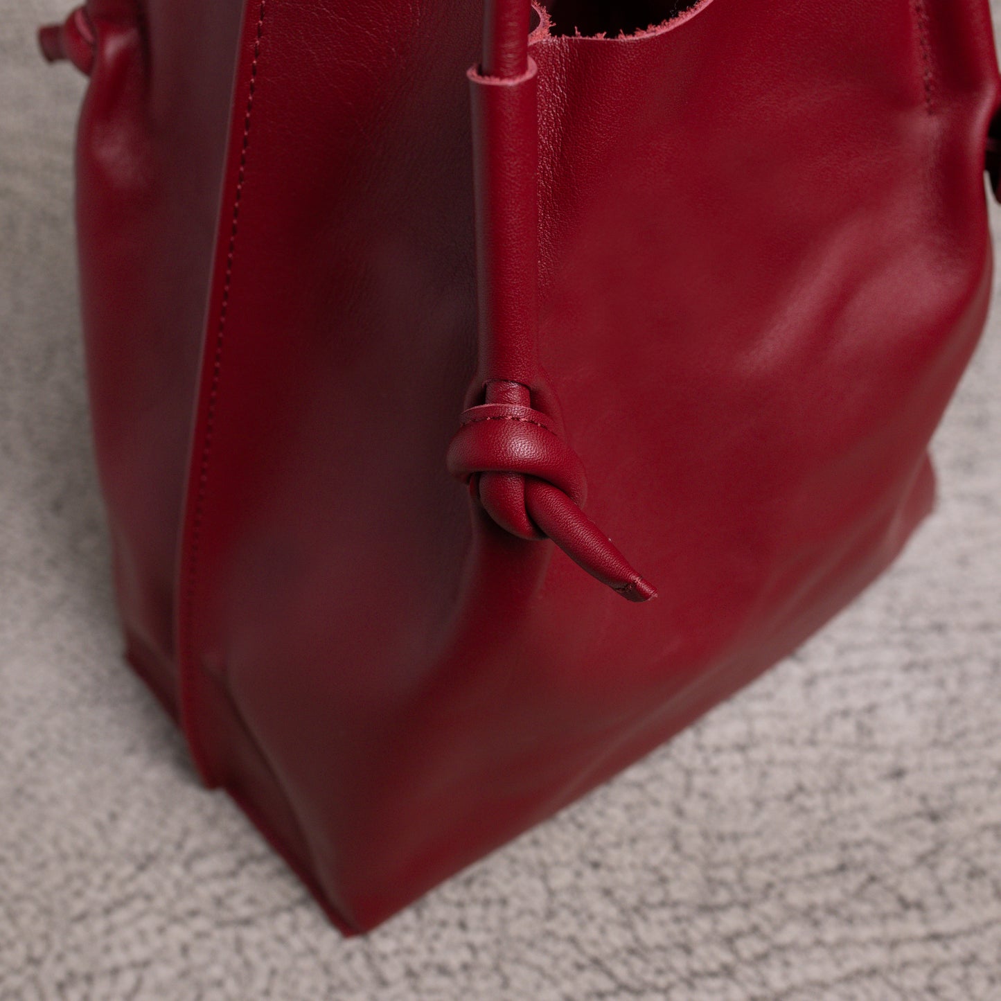 Detailed close-up of the bottom corner and side seam of the Flora Tote, capturing the durability and folded-edge construction of the artisan leather.