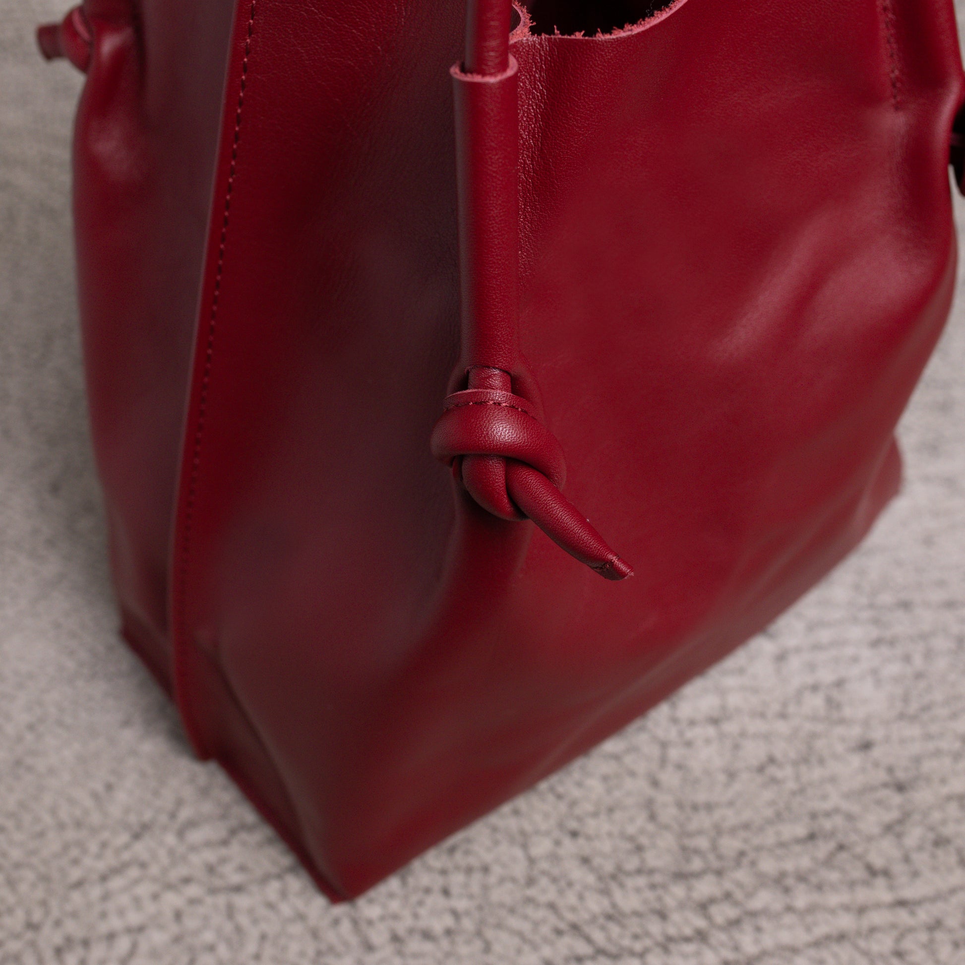 Detailed close-up of the bottom corner and side seam of the Flora Tote, capturing the durability and folded-edge construction of the artisan leather.