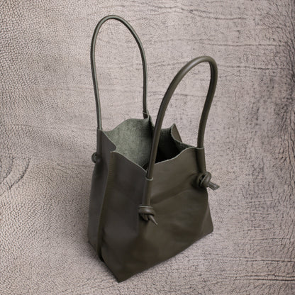 Top-down look inside the Flora Leather Tote in Smooth Calf Green, revealing its raw suede interior and spacious, open-top design.