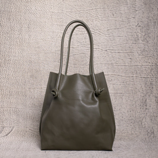 Front view of the Flora Leather Tote in Smooth Calf Green, featuring minimalist knotted handles and clean, structured artisan leather.