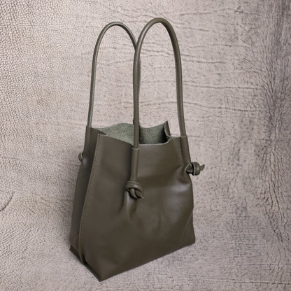 Angled side view of the Flora Tote in Smooth Calf Green, showing the soft suede interior and sculpted silhouette that blends style with utility.