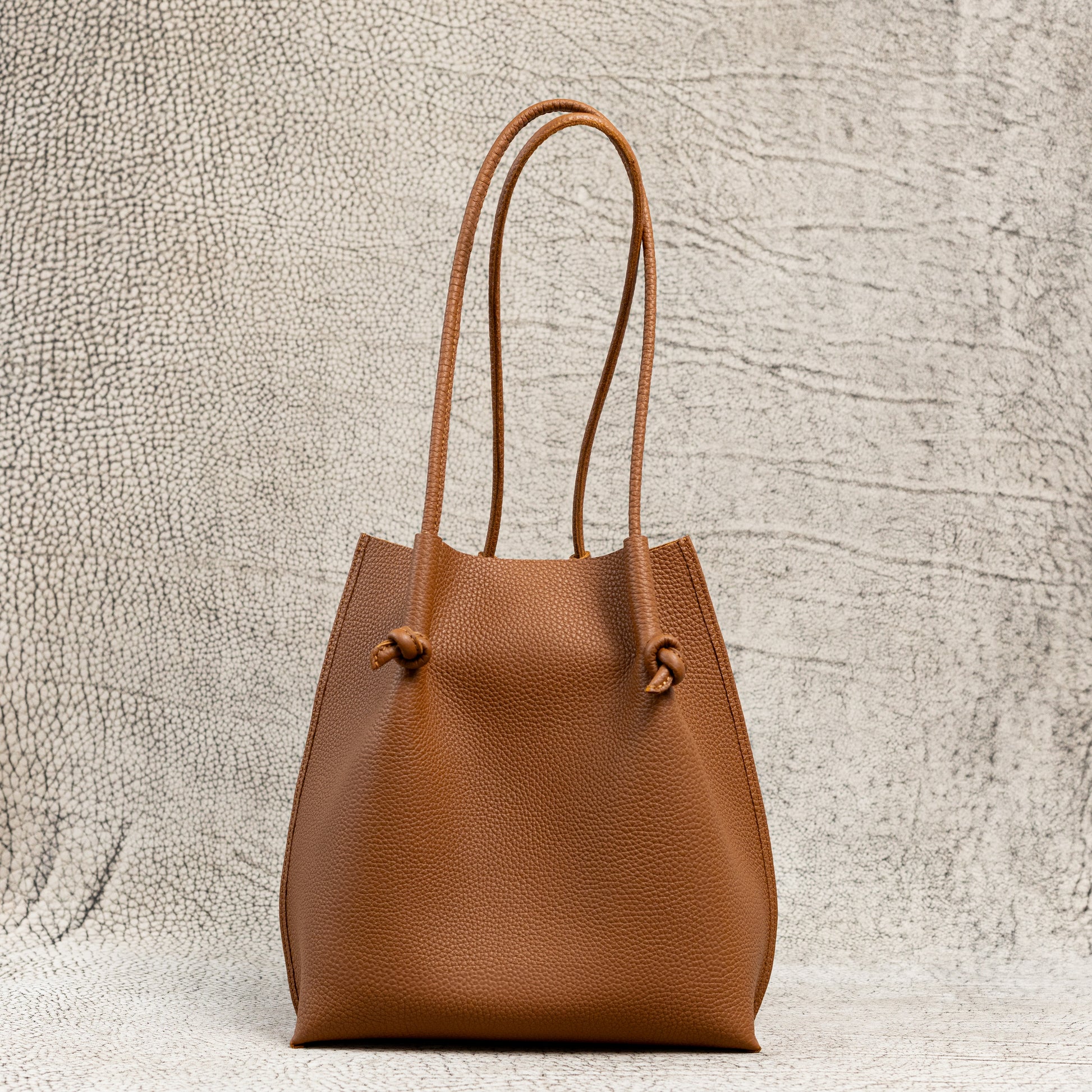 Flora Everyday Leather Tote in Togo Calf Taba with suede interior, rolled handles, and hand-finished edges—crafted for everyday function and rustic charm.