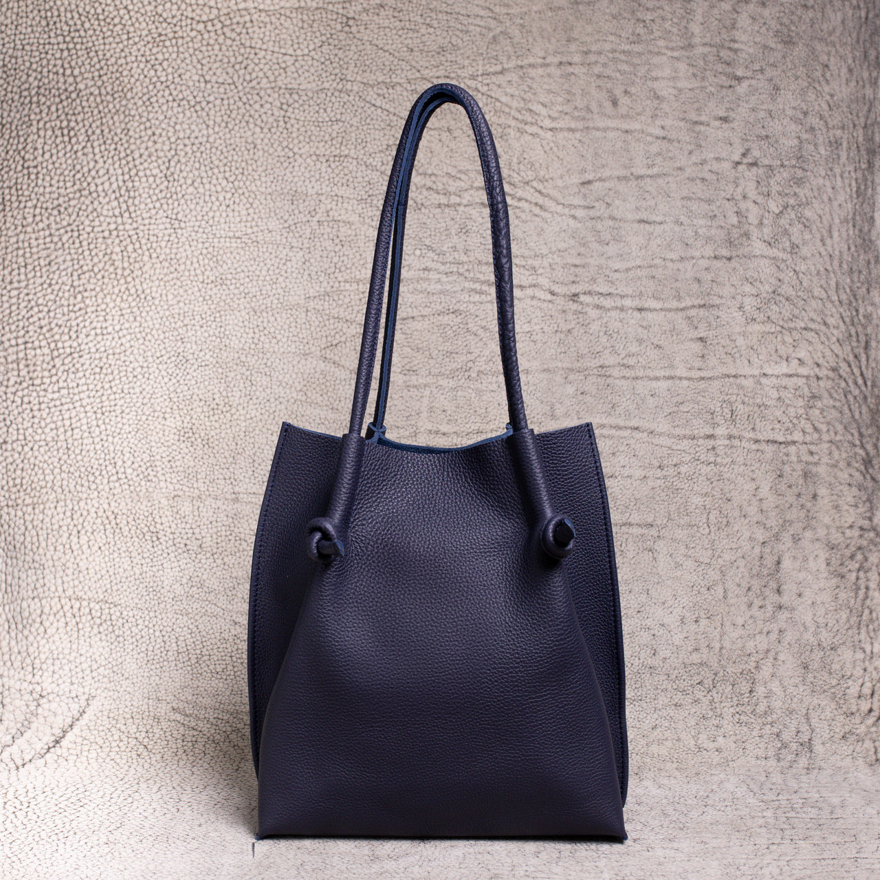 Full frontal shot of the Flora Tote in Togo Blue. Clean silhouette, dual rolled handles, and soft structure express timeless, understated luxury.