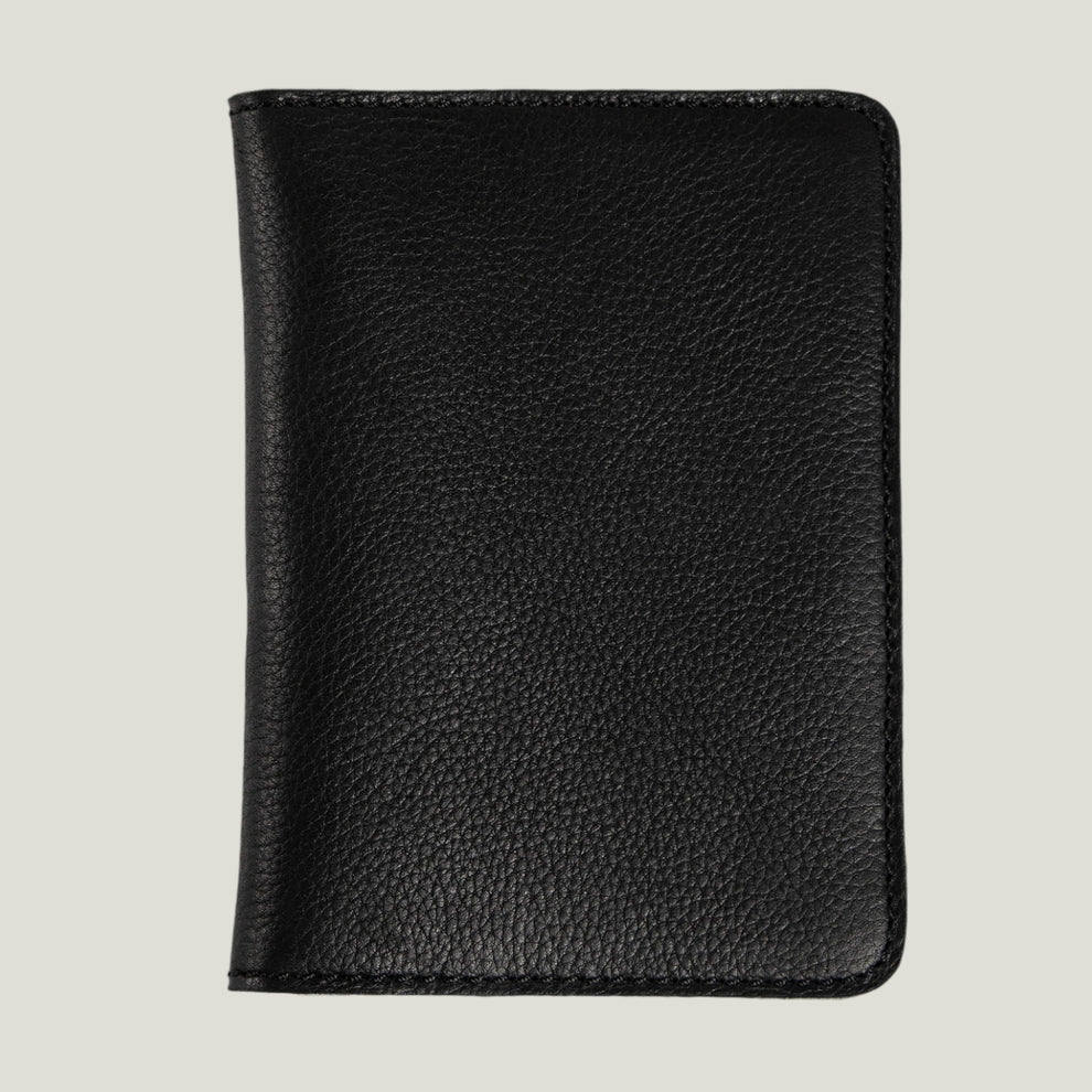 Front view of a black leather passport holder on a light background.