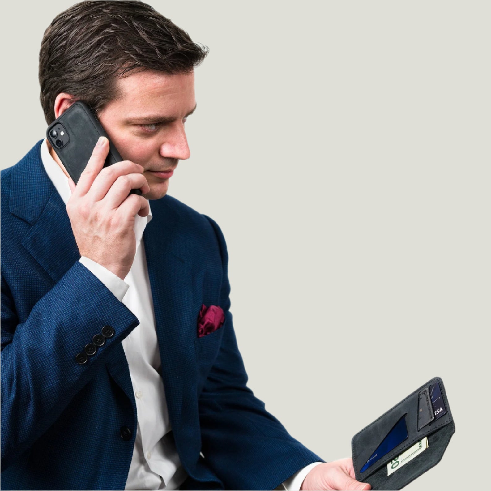 Hand holding a detachable phone case beside its matching leather wallet, showcasing practical everyday use.