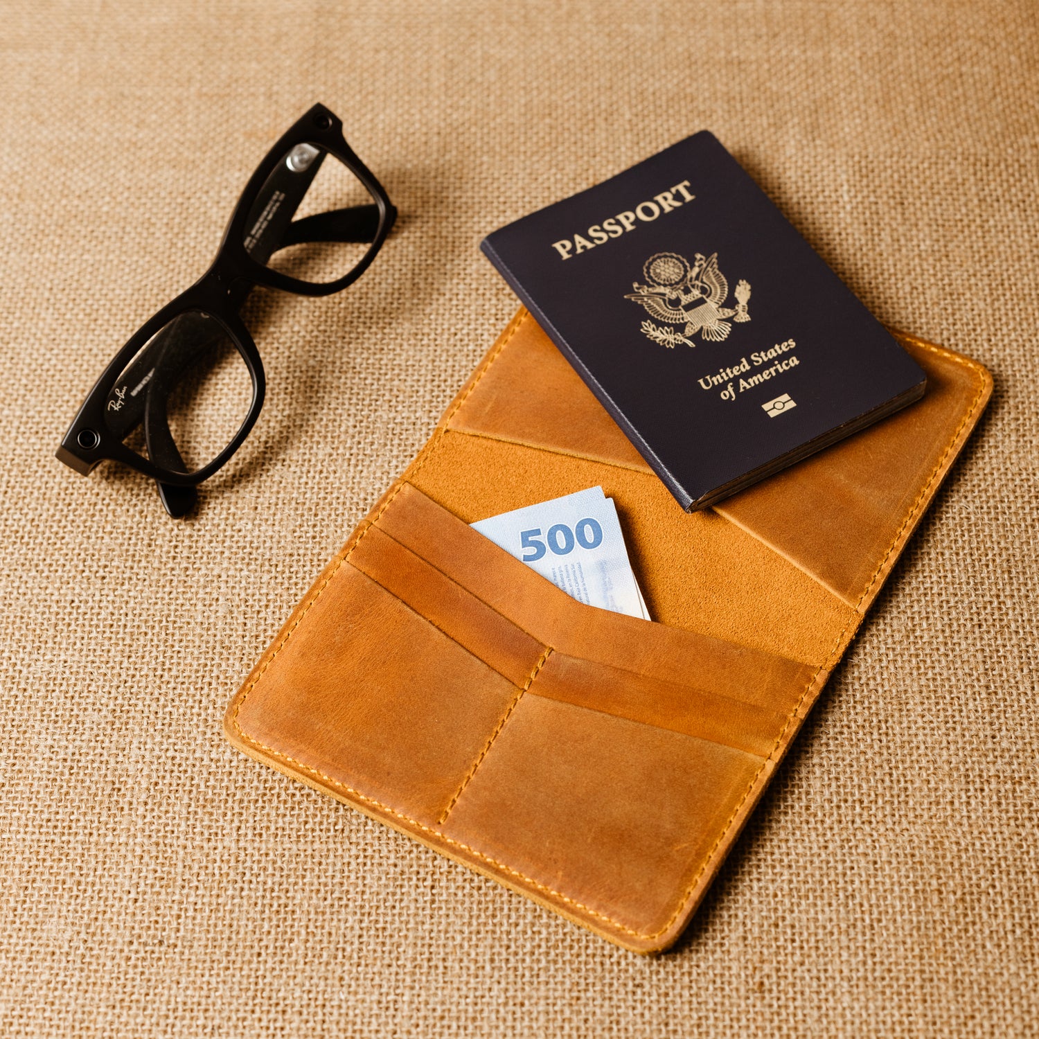 Close-up of the Pike Passport Wallet in rich Cinnamon leather, handcrafted by Atelier PEGAI, with personalized initials fire-branded on the cover.